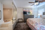 master bedroom suite,king bed, dresser, television, palm leaf style ceiling fan, jacuzzi hot tub, luggage rack